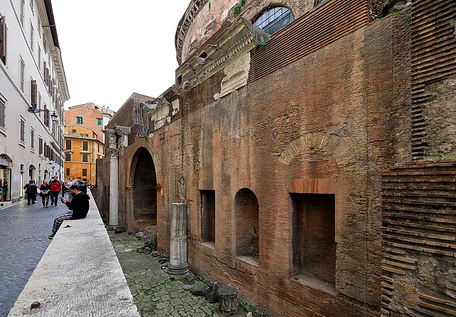 Via della Palombella: the brick outer wall of the Pantheon along the narrow street, with arched niches and a column at its base